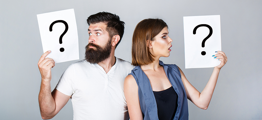 man and woman holding cards with questions marks symbolizing the questions to ask before divorce